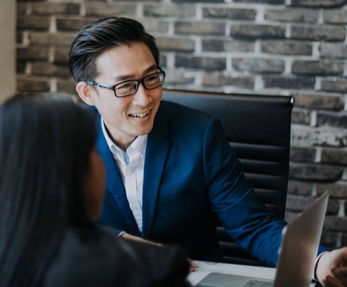 visa-expert Male asian visa expert having an in-depth discussion with businesswoman in the office